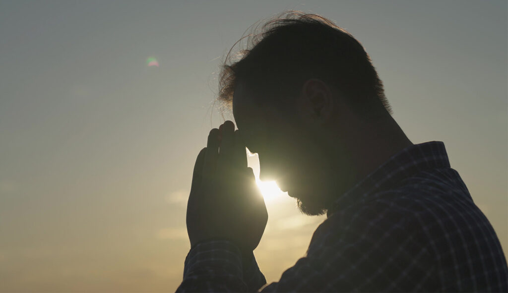 手を合わせて祈る男性